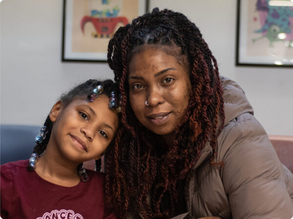 kind-looking woman and her young daughter in the lobby of a doctor's office.